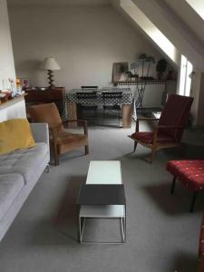 a living room with a couch and chairs and a table at 2 bedrooms in the sky ! in Neuilly-sur-Seine