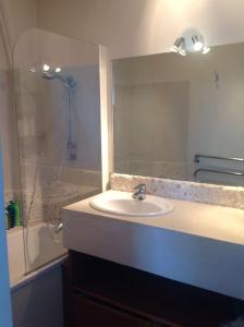 a bathroom with a sink and a shower with a mirror at 2 bedrooms in the sky ! in Neuilly-sur-Seine
