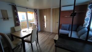 a small living room with a table and a couch at MOBILE HOME FOR YOU in Canet-en-Roussillon