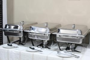 a group of three stainless steel foodstuffs on a table at Johal Mini Hotel -Birmingham City-FREE BREAKFAST in Birmingham