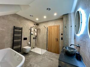 y baño con bañera, lavamanos y ducha. en Luxury Residence Smrzovka - 6 bedrooms, en Jablonec nad Nisou