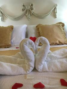 two swans made out of towels on a bed at Casa Rossa in Portovenere