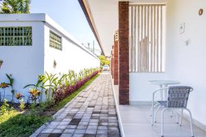 a patio with a table and chairs next to a white wall at OYO 2896 Uma Menuh Guest House Near Pantai Keramas in Keramas