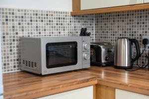 un horno microondas en la parte superior de una barra de cocina en Modern 2 Bed Didcot Home (Free Parking), en Didcot