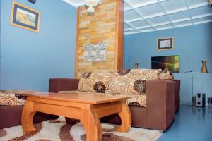 a living room with a table and a couch at COLIBRI VILLA City Center in Gisenyi