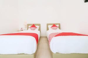 two beds sitting next to each other in a room at OYO 2896 Uma Menuh Guest House Near Pantai Keramas in Keramas