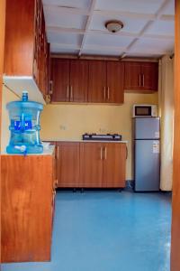 a kitchen with wooden cabinets and a refrigerator at COLIBRI VILLA City Center in Gisenyi