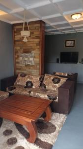 a living room with a bed and a wooden table at COLIBRI VILLA City Center in Gisenyi