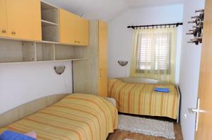 a bedroom with two beds and a window at Apartmani Frakić in Veli Rat