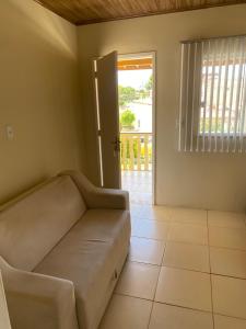 ein Wohnzimmer mit einem Sofa vor einer Tür in der Unterkunft Flat Beira Mar no Condomínio Diver in Vera Cruz de Itaparica