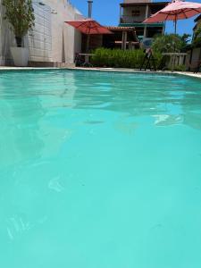 a large swimming pool with blue water at Flat Beira Mar no Condomínio Diver in Vera Cruz de Itaparica