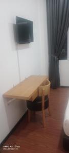 einen Holztisch in einem Raum mit einem Stuhl um ihn herum in der Unterkunft hotel seri liny in Kuching