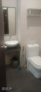 ein Badezimmer mit einem WC, einem Waschbecken und einem Spiegel in der Unterkunft hotel seri liny in Kuching