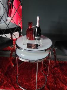 una mesa con una botella de vino y copas. en Love freedom bdsm, en Iaşi