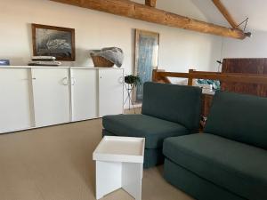 sala de estar con 2 sillas y mesa en La Grange aux hirondelles - appartement complet et indépendant, en Commelle-Vernay