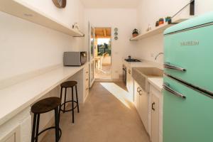 een keuken met witte kasten en een blauwe koelkast bij I Farasuli in Marina Porto