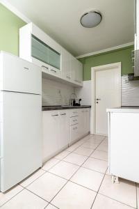 cocina con electrodomésticos blancos y paredes verdes en Sunshine, en Subotica