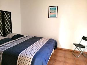 a bedroom with a bed and a chair in it at Situation parfaite, calme et spacieux, Wifi fibre, Netflix & Prime in Béziers
