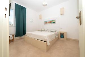een slaapkamer met een bed en een groen gordijn bij I Farasuli in Marina Porto