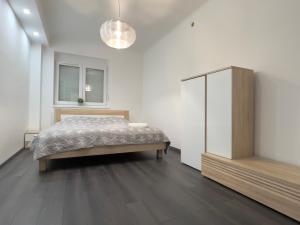 ein Schlafzimmer mit einem Bett und einem Schrank darin in der Unterkunft pecsiapartmanok - K2 Apartman in Pécs