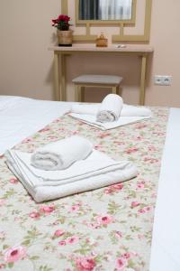 two towels are sitting on a bed with a table at Anastasia's Luxury House in Kavála