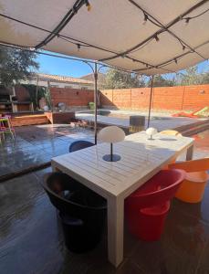 uma mesa de madeira com cadeiras debaixo de um guarda-sol em Superbe maison avec piscine em Vinassan