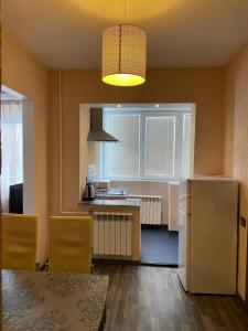 a kitchen with a refrigerator and a table with chairs at Cat Garden Superior Apartments Riga in Rīga