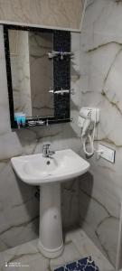 y baño con lavabo blanco y espejo. en Qusar-A-frame en Qusar