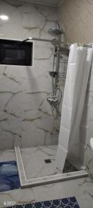 a bathroom with a shower and a white marble wall at Qusar-A-frame in Qusar
