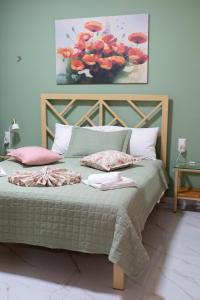 a bed with a green comforter and pillows on it at Anastasia's Luxury House in Kavála