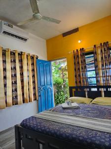 a bedroom with a bed and a blue door at Peace and love stay in Alleppey