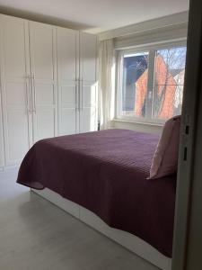 - une chambre avec un lit violet et une fenêtre dans l'établissement apartment 2 miles from Maastricht, à Lanaken