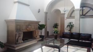 a living room with a couch and a fireplace at Hotel San Xavier in Querétaro