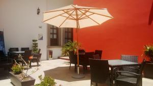 a table and chairs with an umbrella in a room at Hotel San Xavier in Querétaro