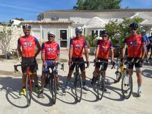 a group of men in red shirts posing on their bikes at Hostal Residencia Alma in Port d'Alcudia