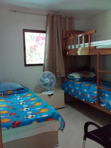 a bedroom with two bunk beds and a fan at CASA NO CONDOMÍNIO CAMINHO DA SERRA in Bananeiras