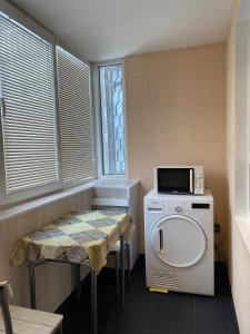 a small room with a washing machine and a microwave at Cat Garden Superior Apartments Riga in Rīga