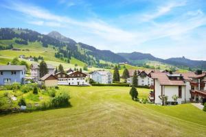 a village in the mountains with a green field at helle moderne 3,5-Zimmer-Wohnung 84m2 in Oberiberg