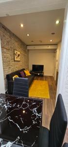 een woonkamer met een bank en een tafel bij Highgate Duplex Guest Flat in Londen