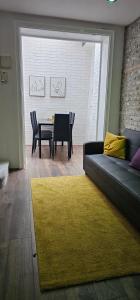 een woonkamer met een bank en een tafel met stoelen bij Highgate Duplex Guest Flat in Londen
