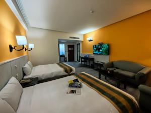 a hotel room with a bed and a couch and a tv at Travel Road Motel in Hualien City