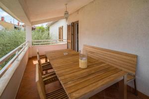 una mesa de madera con 2 sillas en el balcón en Villa More Mio, en Poreč