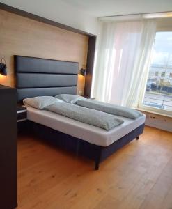 奧格斯堡的住宿－MitZeit 5-154 qm Inklusive Terrasse und Parkplätze，卧室设有一张大床,卧室设有大窗户