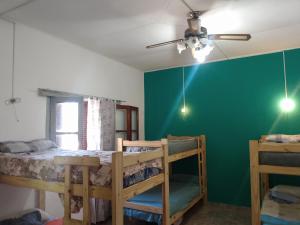 sypialnia z 2 łóżkami piętrowymi i zieloną ścianą w obiekcie RHOMBUS HOSPEDAJE Y HABITACIONES w mieście Guaymallén