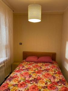 a bedroom with a bed with a colorful blanket at Cat Garden Superior Apartments Riga in Rīga