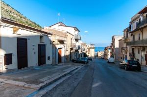 une rue urbaine vide avec des voitures garées sur la route dans l'établissement White Home, à Castellammare del Golfo