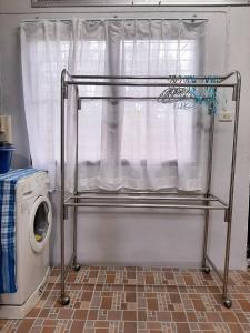 a drying rack next to a window with a washing machine at Rutcha homestay Betong รัชชา โฮมสเตย์ เบตง in Betong