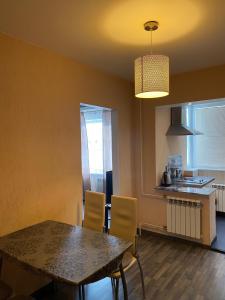 a kitchen and dining room with a table and chairs at Cat Garden Superior Apartments Riga in Rīga