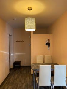 a dining room with a table and white chairs at Cat Garden Superior Apartments Riga in Rīga