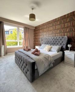 a bedroom with a large bed with a large window at The Naburn - 3 Bed House with Free Parking & Close to City Centre in Glasgow